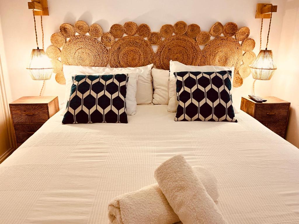 a large bed with a large wooden headboard and pillows at Casa 1928 - 1 DER - Plaza de España in Seville