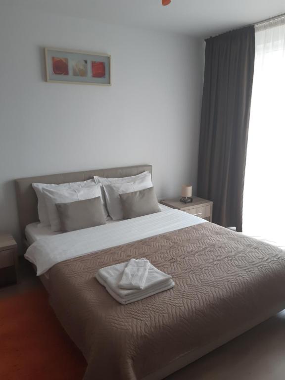 a bedroom with a large bed with a towel on it at Apartament Marcel - Coresi Mall in Braşov