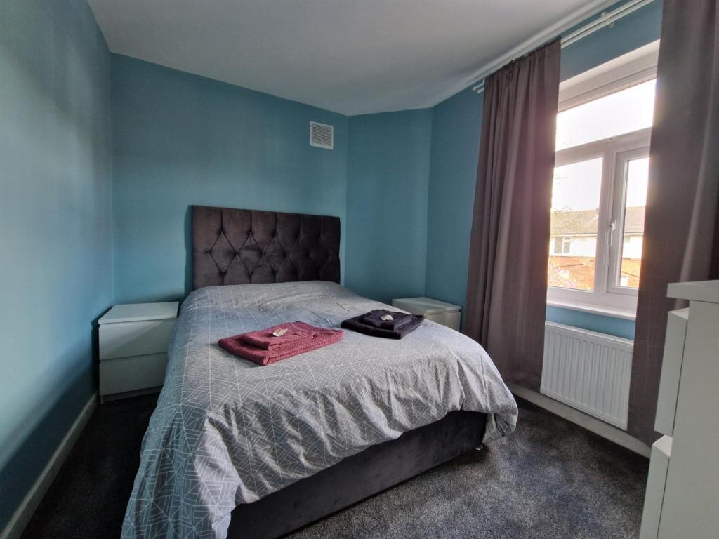 a bedroom with a bed with a red jacket on it at Pav's Den in Ince-in-Makerfield