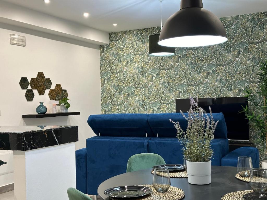 sala de estar con sofá azul y mesa en Amour Içi appartamenti e suite in centro en Mascalucia