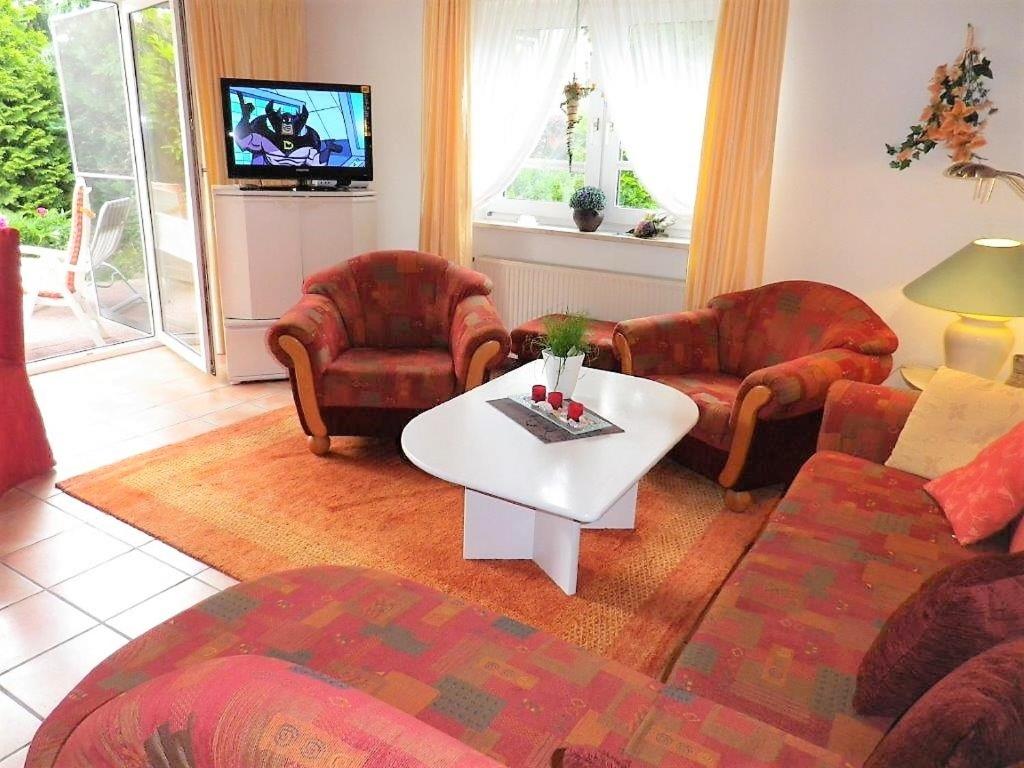 ein Wohnzimmer mit einem Sofa, Stühlen und einem Tisch in der Unterkunft Pension Hermer in Grömitz