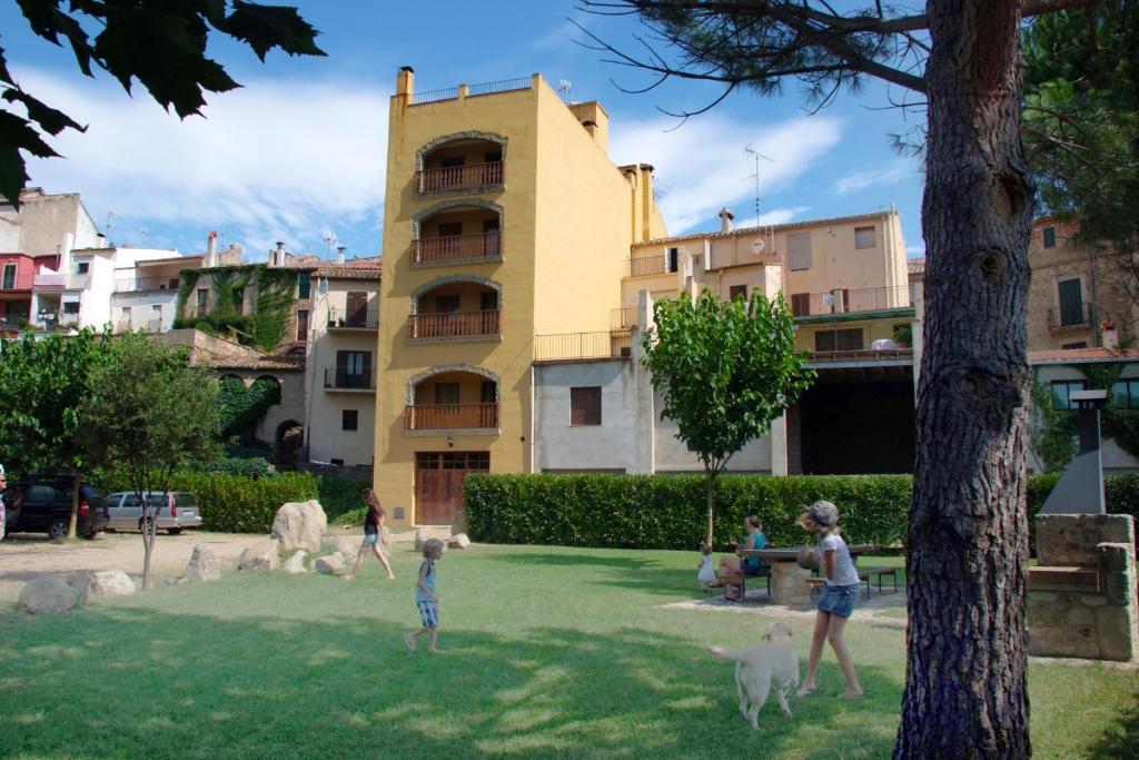 un groupe d'enfants jouant avec des chiens dans un parc dans l'établissement Apartamentos Cal Ratero, à Maçanet de Cabrenys