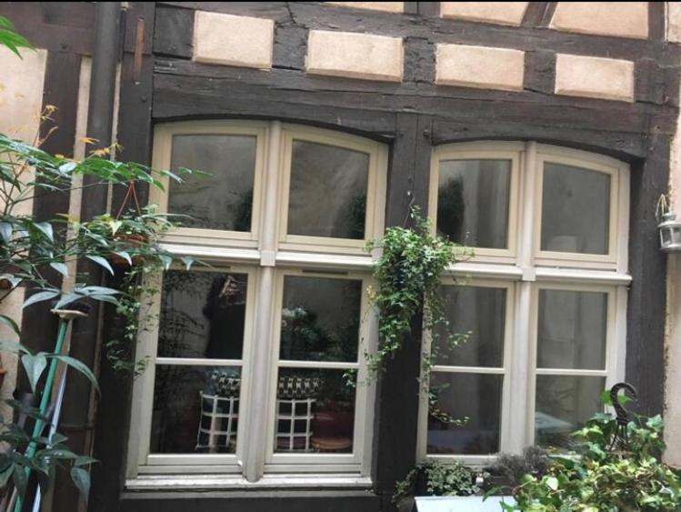 un bâtiment avec trois fenêtres sur son côté dans l'établissement Triplex avec terrasse, aux pieds de la cathédrale, 5 personnes, à Strasbourg