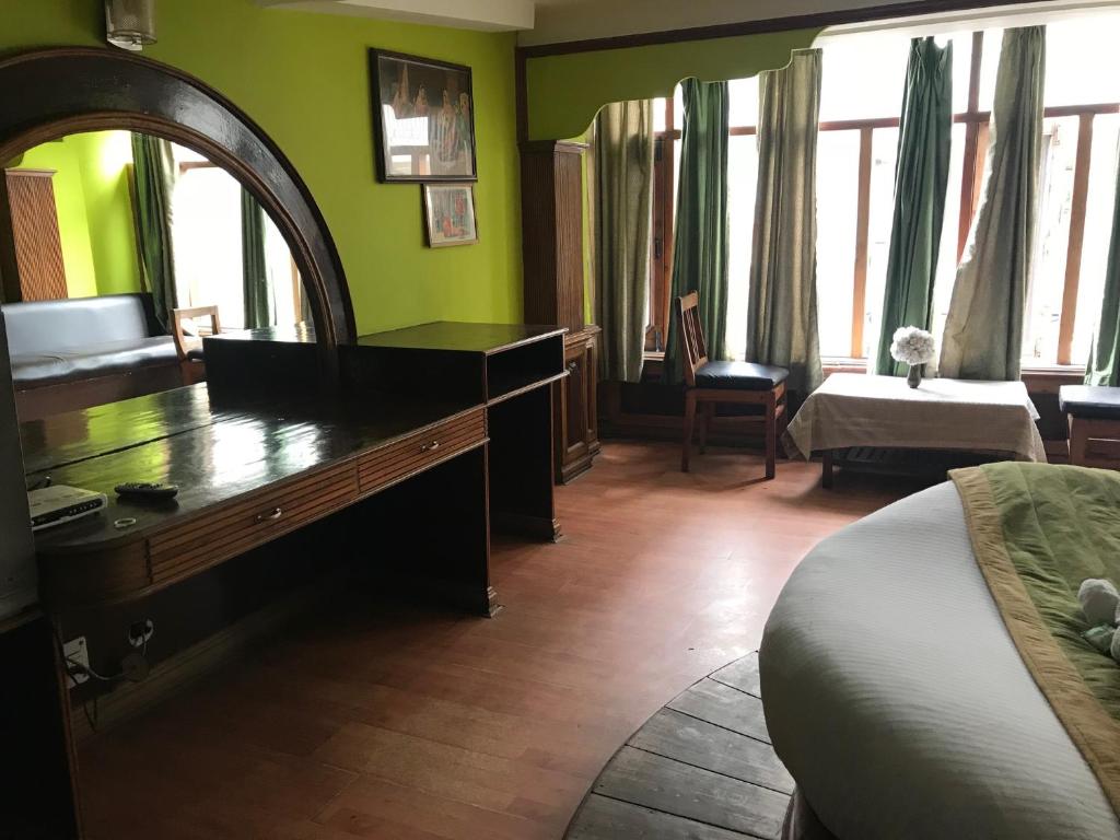 a bedroom with a desk and a mirror and a bed at Kamya INN, Puri in Puri