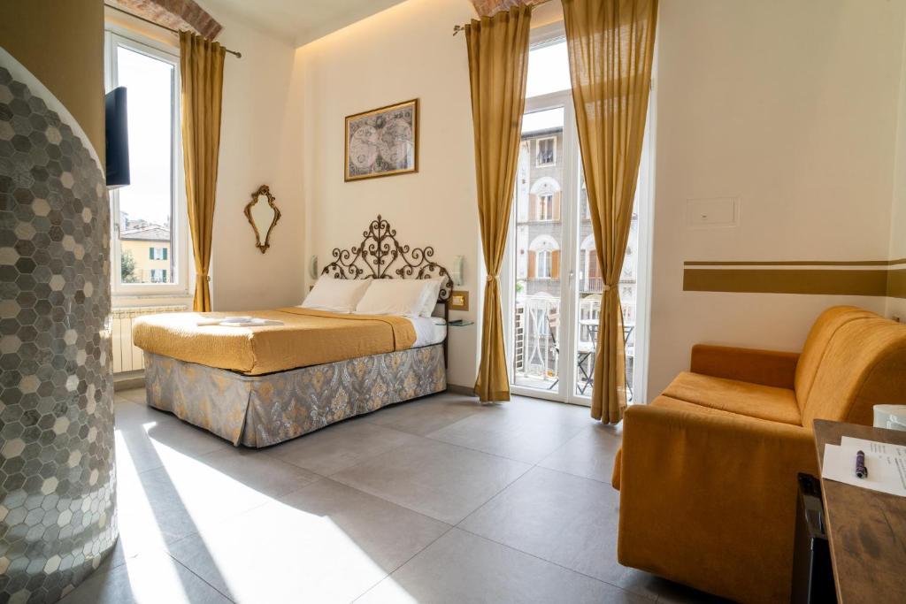 een slaapkamer met een bed, een stoel en ramen bij Teresa Rooms & Suites in La Spezia