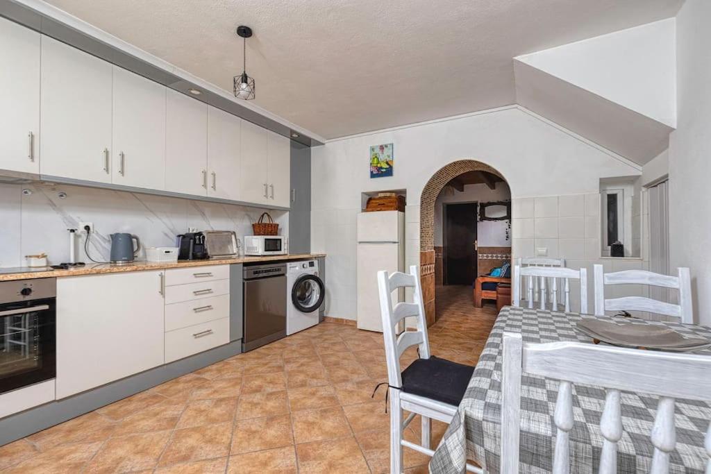 een keuken en eetkamer met een tafel en stoelen bij Casa dos Peixinhos - Rogil in Rogil