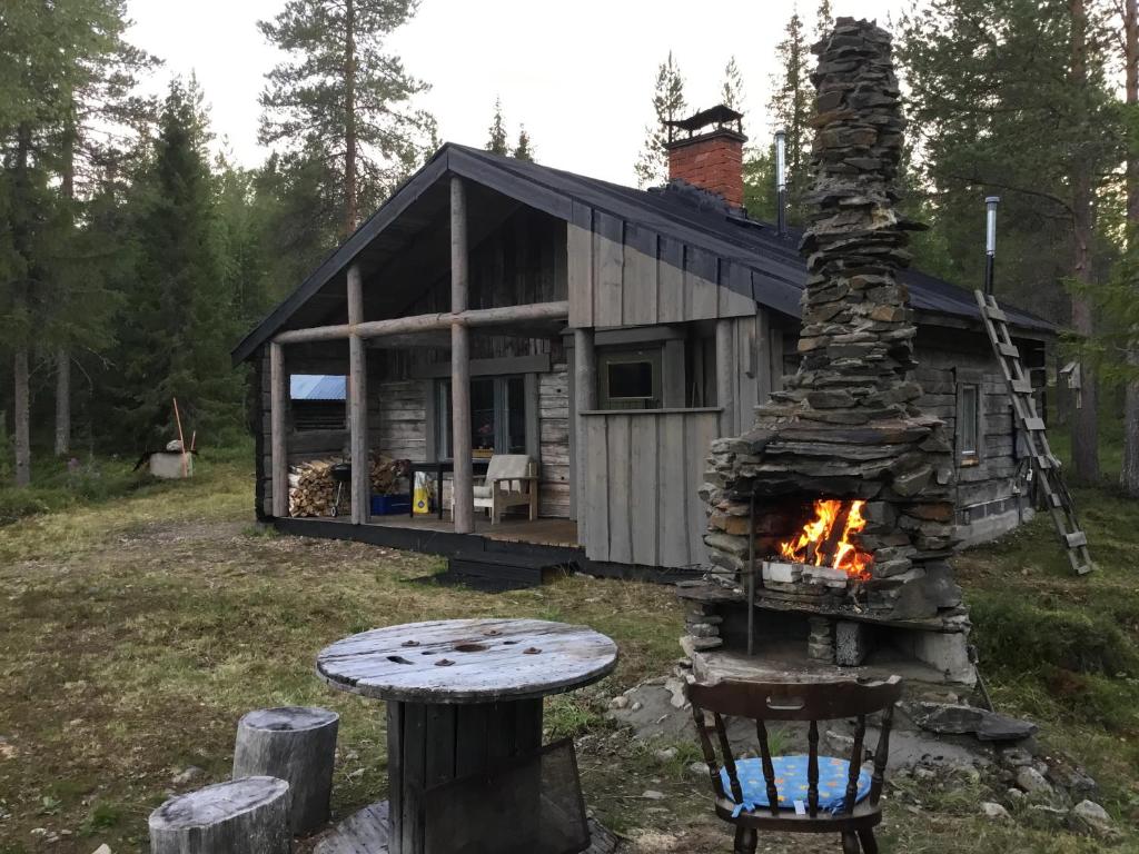 a cabin in the woods with a fire pit at Ylläsjärvi in Kittilä