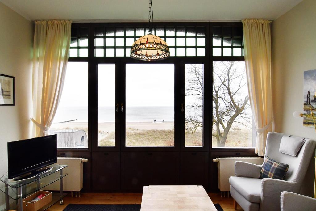 a living room with a large window with a view of the beach at Strandklause-App-04 in Seebad Bansin in Heringsdorf
