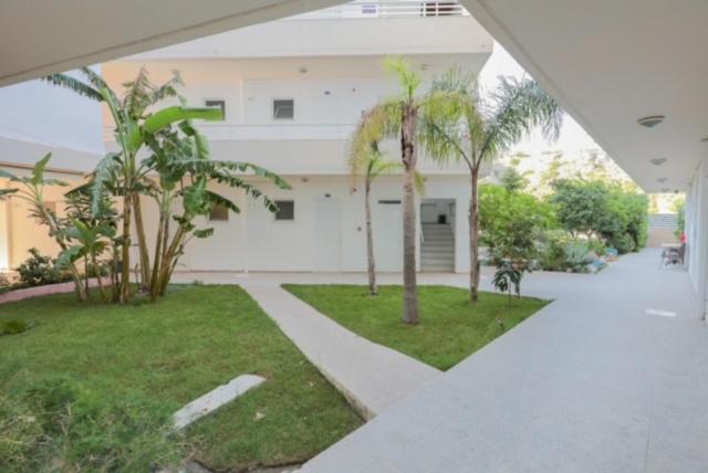 een binnenplaats met palmbomen en een gebouw bij Faliraki Dream Apartments & Studios in Kallithea Rhodes