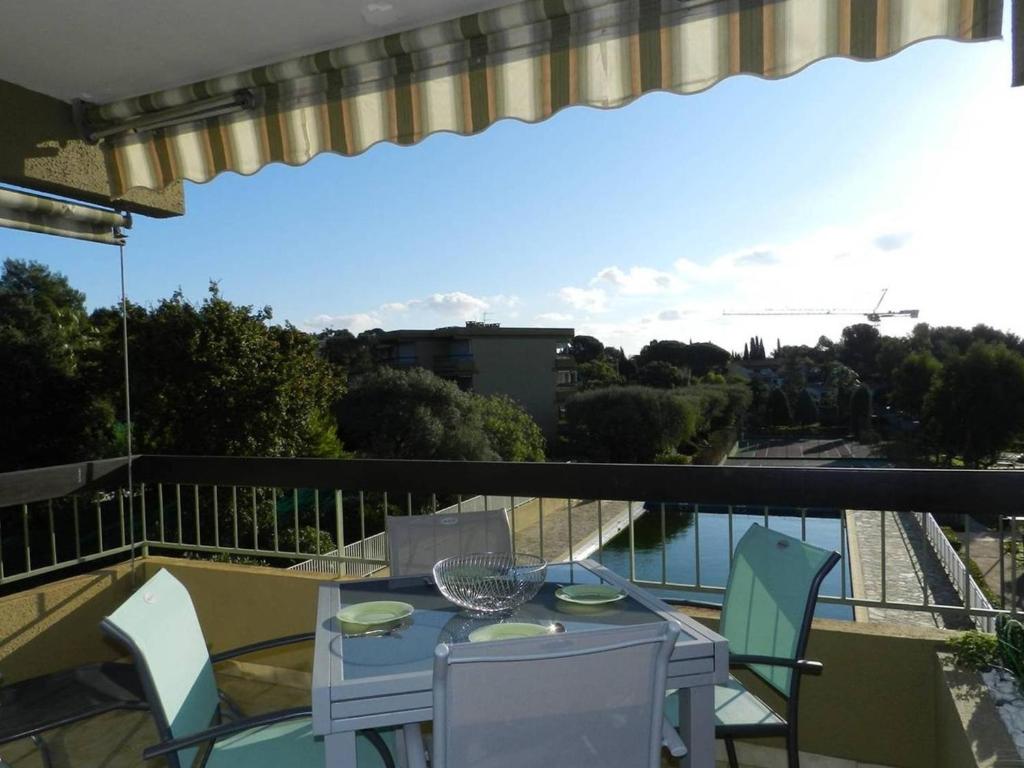 une table et des chaises sur un balcon avec vue dans l'établissement Appartement 2 pièces avec piscine, proche plage et commerces - Bormes-les-Mimosas - FR-1-251-796, à Bormes-les-Mimosas