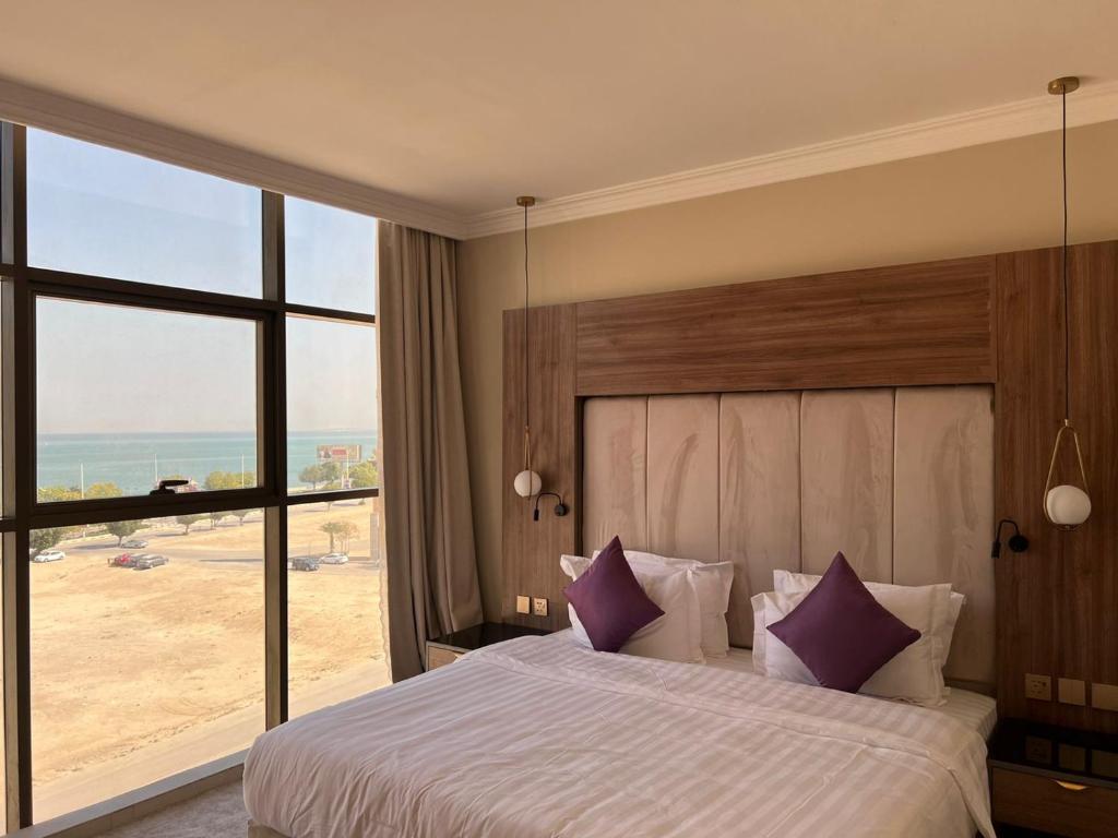 Schlafzimmer mit einem Bett und Strandblick in der Unterkunft لافانتا للشقق المخدومه - LAVANTA Hotel in Khobar