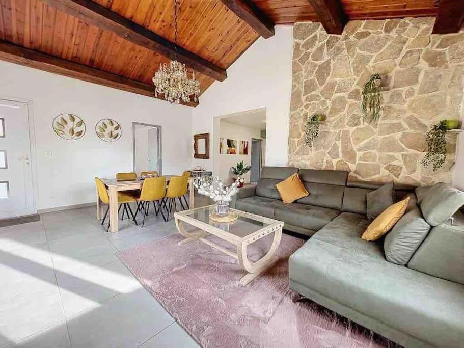 uma sala de estar com um sofá e uma mesa em Villa avec piscine em Montpellier