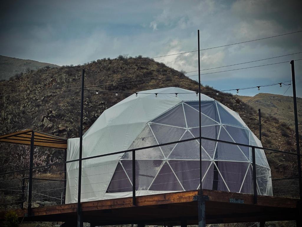 a domed building with a mountain in the background at Vardzia Glamping in Vardzia