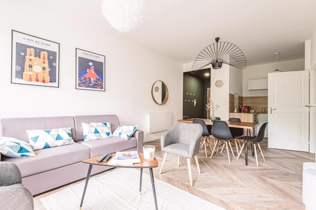 un salon avec un canapé et une table dans l'établissement HENRI au pied de la cathédrale., à Reims