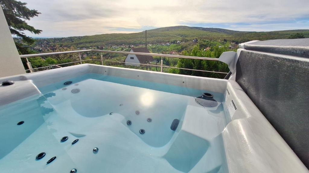 a hot tub on a balcony with a view at Hillside Cottage in Pécs