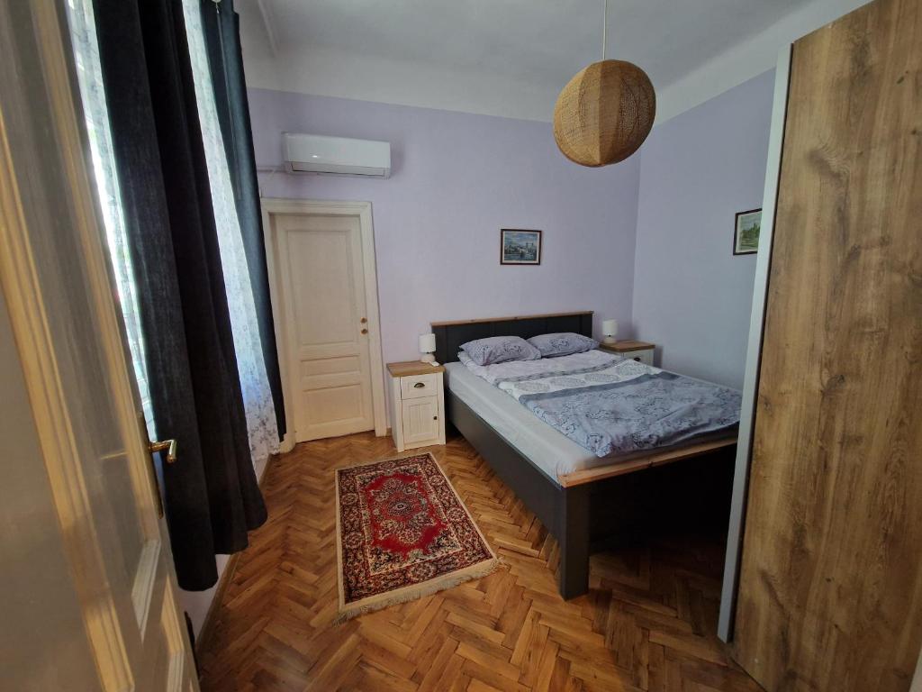 um pequeno quarto com uma cama e um tapete em Етаж от къща с двор em Burgas