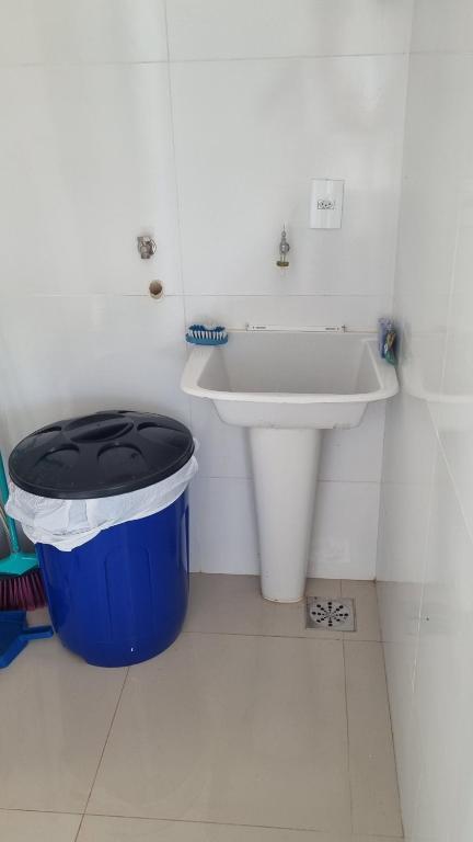 a bathroom with a trash can and a sink at Luxo colado no Shopping in Franca