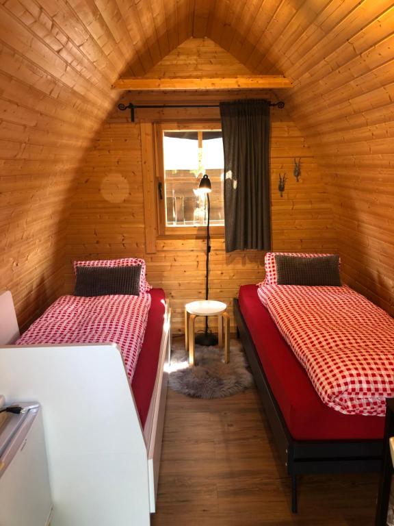Zimmer mit 2 Betten in einer Holzhütte in der Unterkunft Bezauberndes Gartentiny in Steffisburg