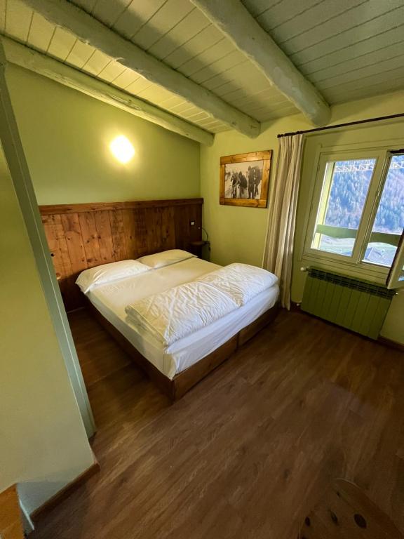 a bedroom with a bed in a room with a window at Hotel Riva Sport & Wellness in Vione