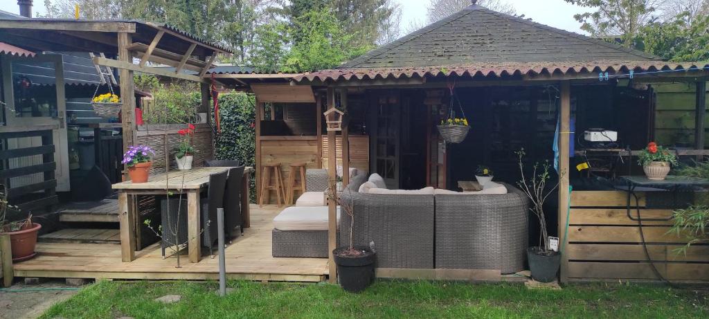a gazebo with a bench and a table at "Tempat Senang" chalet on the beautiful Veluwe with airco sauna bbq jacuzzi beamer and dog in Putten