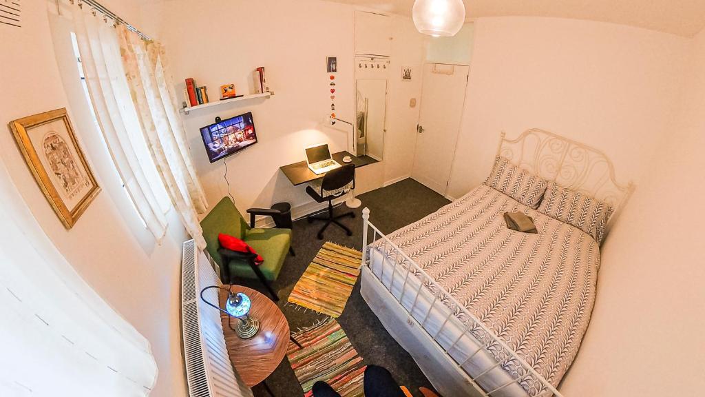 a small living room with a bed and a table at Centrally Located Comfortable Room in London in London