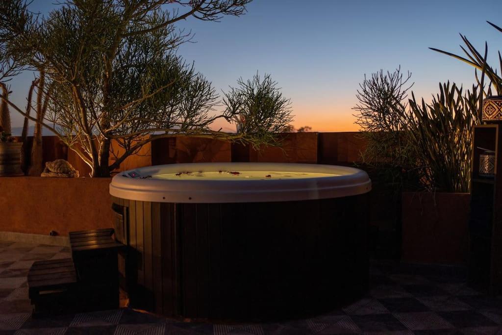 un jacuzzi en un patio con puesta de sol en Penthouse avec Jacuzzi privé à Marrakech, en Marrakech