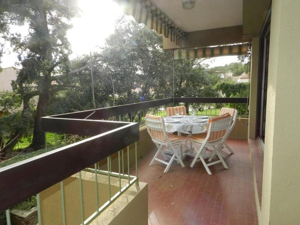un patio avec une table et des chaises sur un balcon dans l'établissement Appartement familial avec piscine et tennis, proche plage - 6 couchages, Bormes-les-Mimosas - FR-1-251-817, à Bormes-les-Mimosas