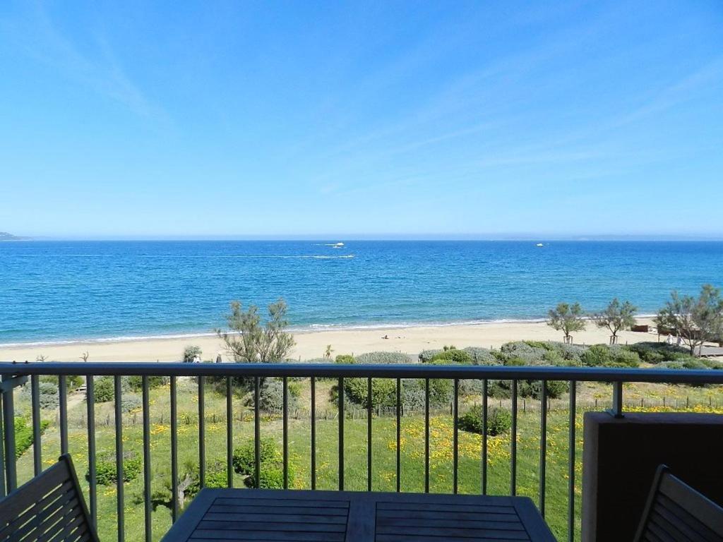 une vue sur la plage depuis le balcon d'un condo dans l'établissement Appartement T2, 4 couchages, parking, bord de mer - FR-1-251-820, au Lavandou