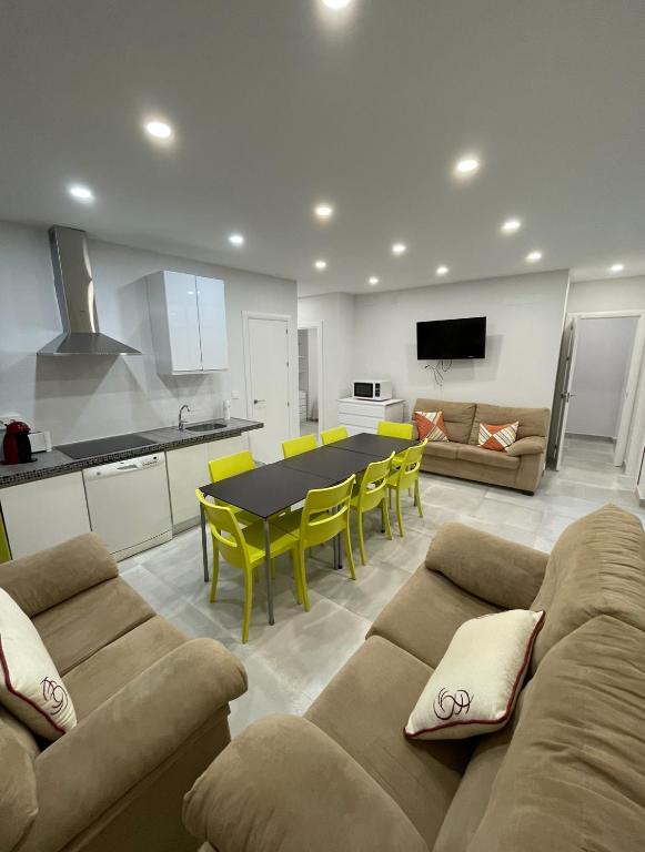 a kitchen and a living room with a couch and a table at Casa amplia ideal en pleno centro del casco histórico de Almuñecar in Almuñécar