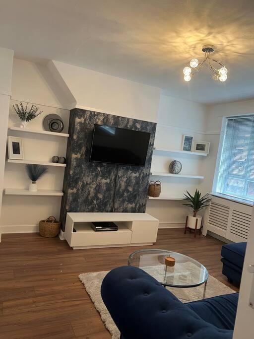 een woonkamer met een flatscreen-tv aan de muur bij Flat in White city - Westfield in Londen