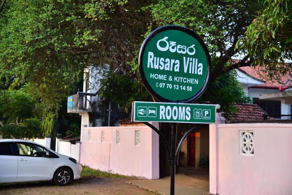 a sign for a risseria villa in front of a car at Rusara Villa in Tissamaharama