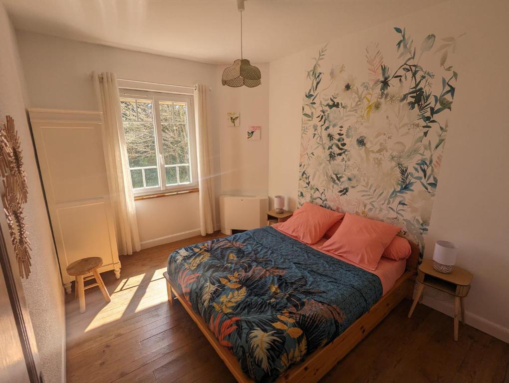 Schlafzimmer mit einem Bett mit Wandgemälde in der Unterkunft Le Domaine de la Croze in Gramat