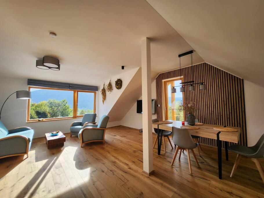 a living room with a staircase and a table and chairs at Krásný apartmán REFRINO v přírodě in Železná Ruda
