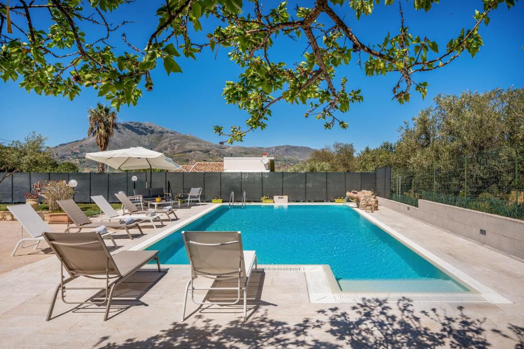 una piscina con tumbonas y sombrilla en Villa Miceli, en Scopello