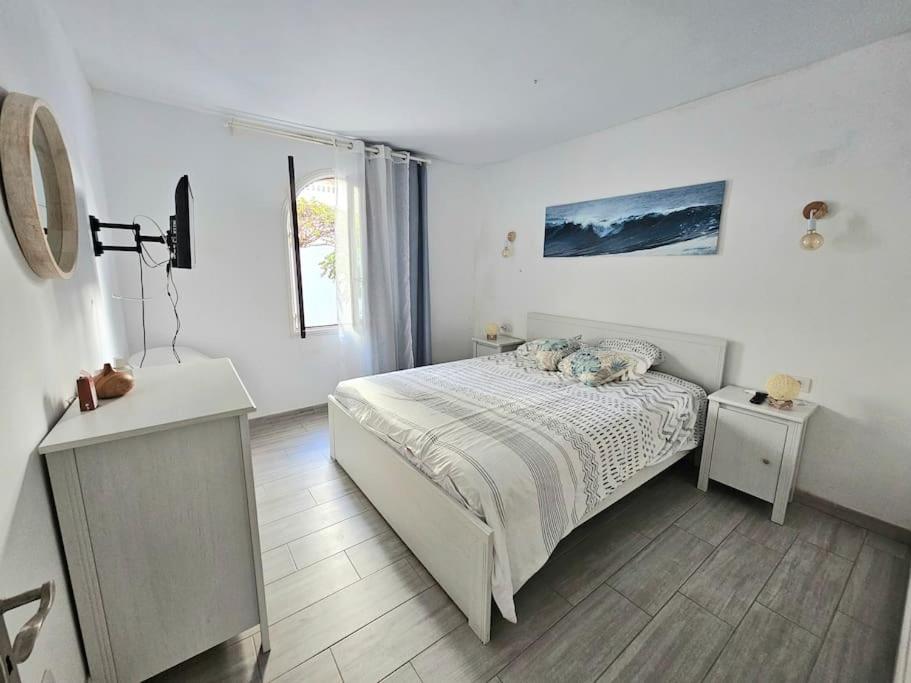 Habitación blanca con cama y ventana en Apartamento con piscina a 500m de la playa, en Costa Teguise