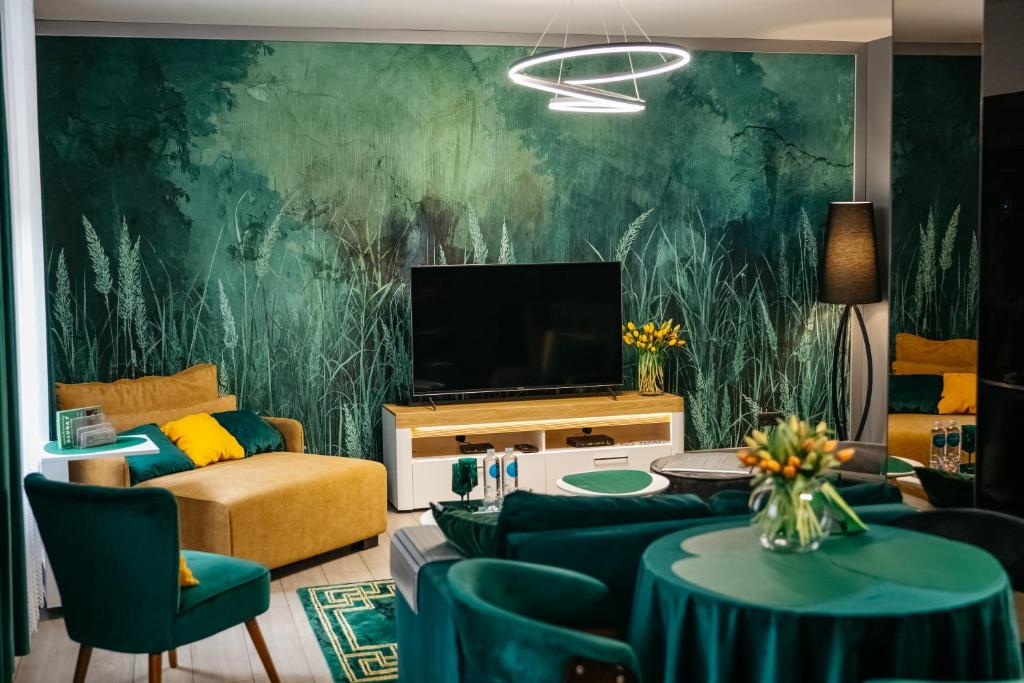 - un salon avec un canapé et une télévision dans l'établissement Apartamenty Długa 7, à Racibórz