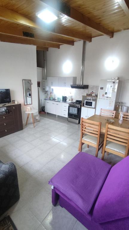 ein Wohnzimmer mit einem lila Sofa und einer Küche in der Unterkunft Alquiler Temporario Río Grande in Río Grande