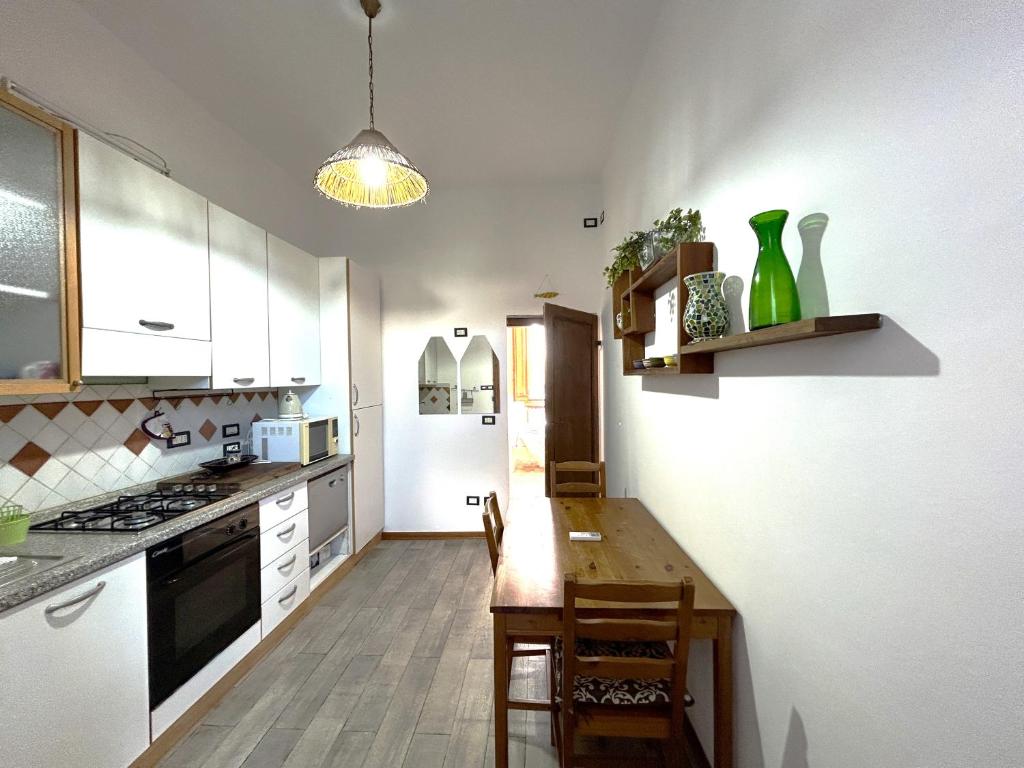 kuchnia ze stołem i białą lodówką w obiekcie Appartamento Firenze Mayer we Florencji