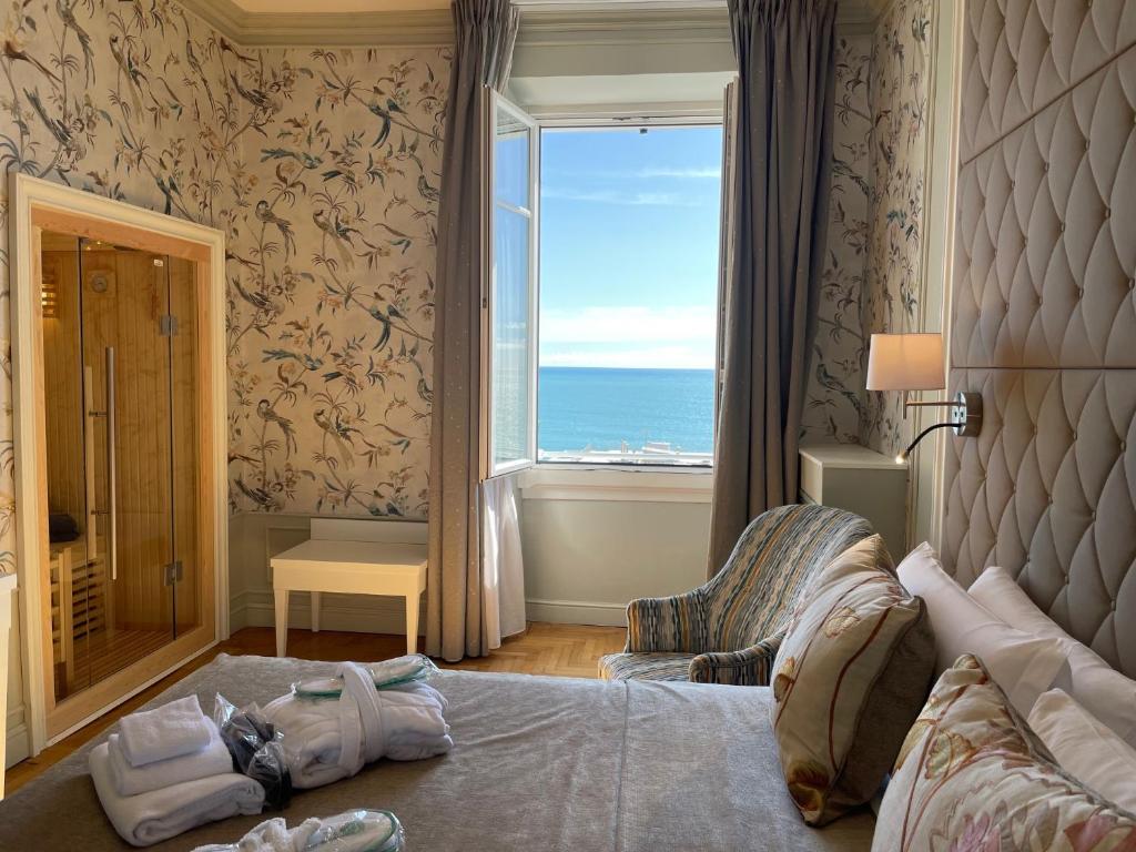 a bedroom with a bed and a large window at Grand Hotel & des Anglais in Sanremo