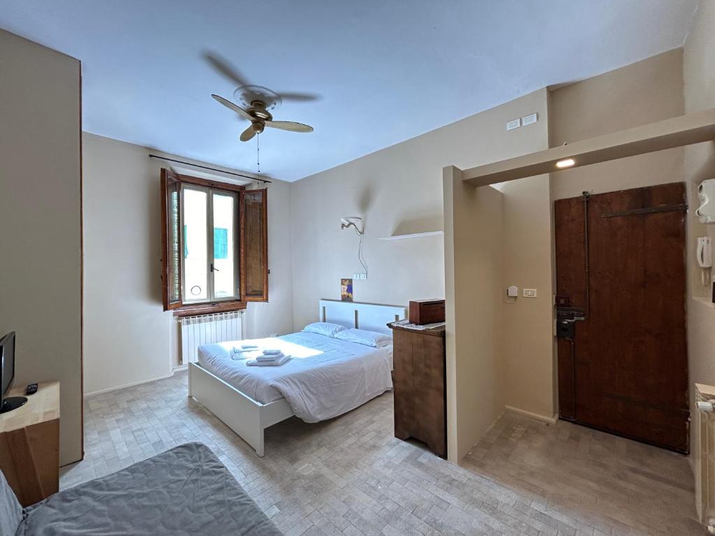 sypialnia z łóżkiem i wentylatorem sufitowym w obiekcie Appartamento Firenze Mayer we Florencji