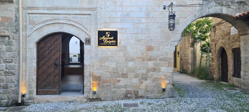 een toegang tot een gebouw met een bord erop bij Ancient Knights Luxury Suites in Rhodos-stad
