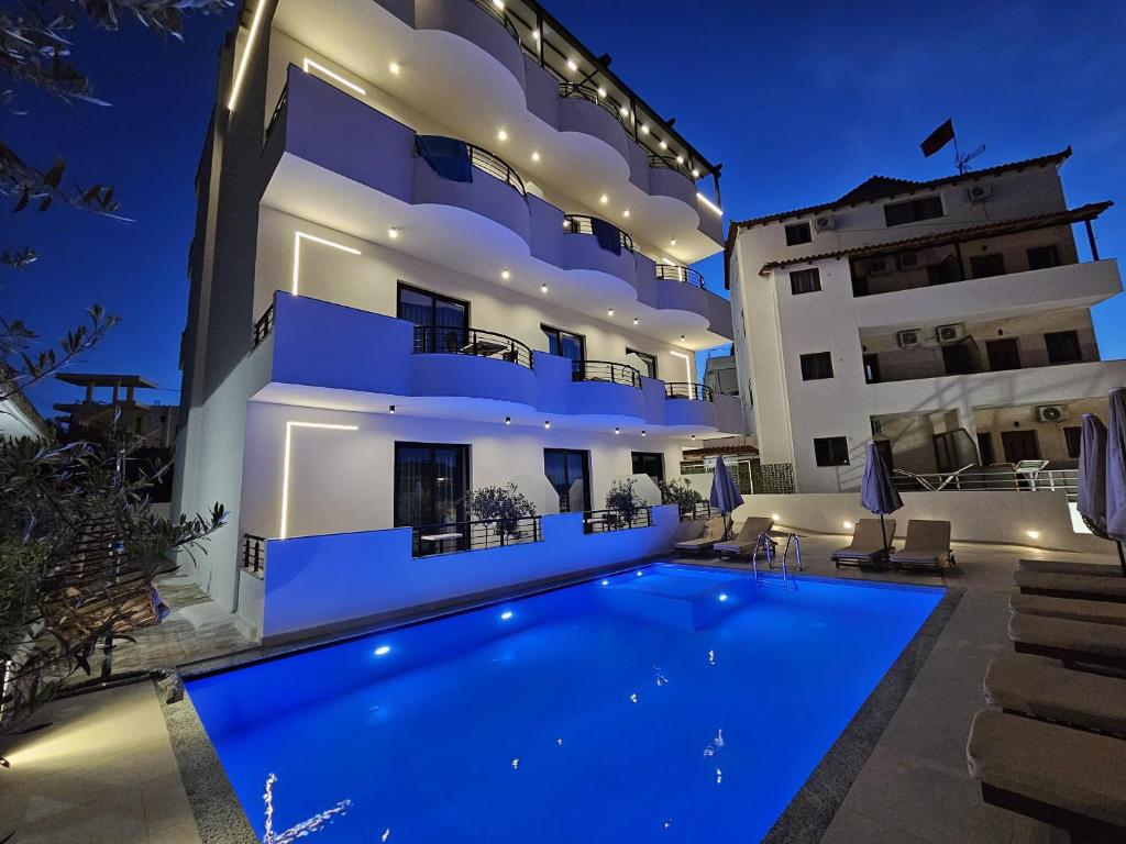 a villa with a swimming pool at night at Monel Hotel in Ksamil