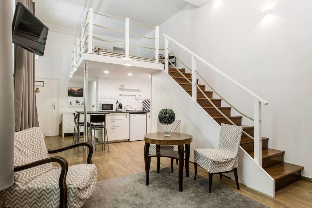 a living room with a staircase and a table and chairs at 57 Steps from the Basilica in Budapest