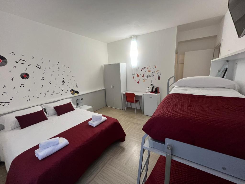 a bedroom with two beds with red and white sheets at La Lirica rooms in Verona