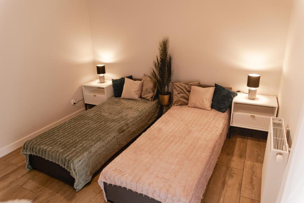 2 łóżka w małym pokoju z 2 stolikami nocnymi w obiekcie Apartament Rozmarynowa Residence 8 Opole w mieście Opole