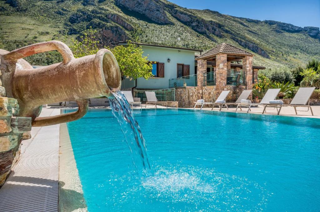 une fontaine au milieu d'une piscine dans l'établissement Villa Miceli con piscina privata, à Scopello