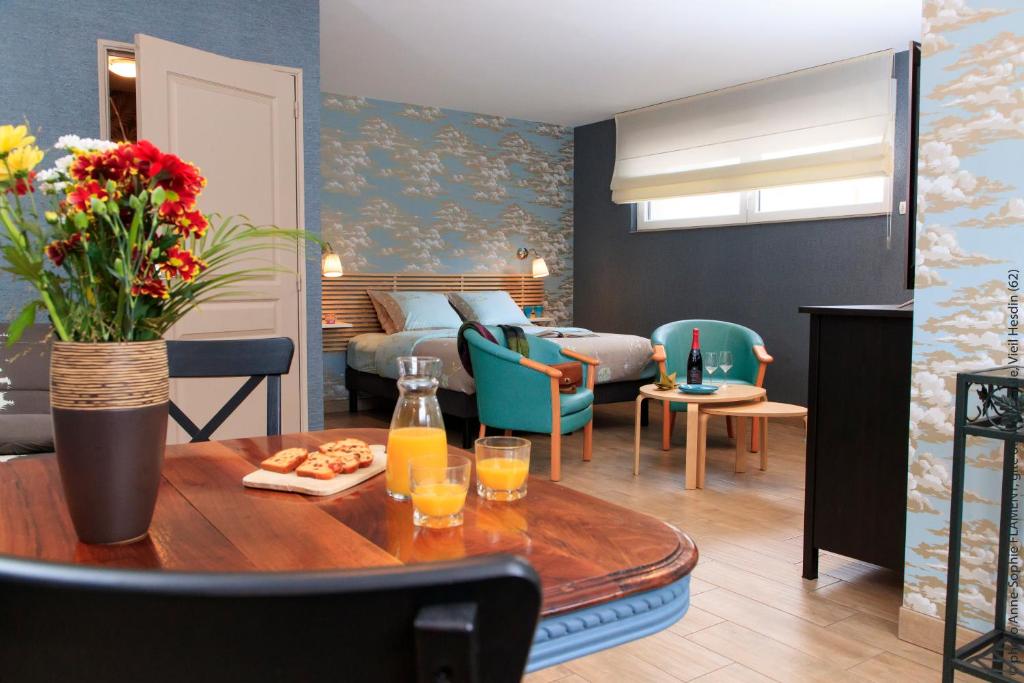 uma sala de estar com uma cama e uma mesa em gite du vieux saule et spa em Vieil-Hesdin