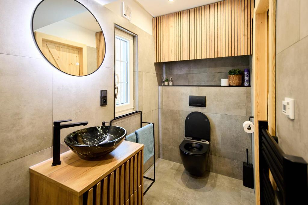 ein Bad mit einem Waschbecken und einem Spiegel in der Unterkunft Privátní chata Dori se saunou v ceně in Kouty