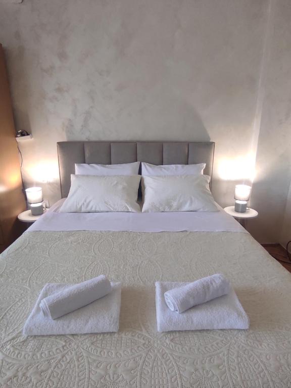 a bed with two white towels on top of it at Apartment Clock Tower in Podgorica