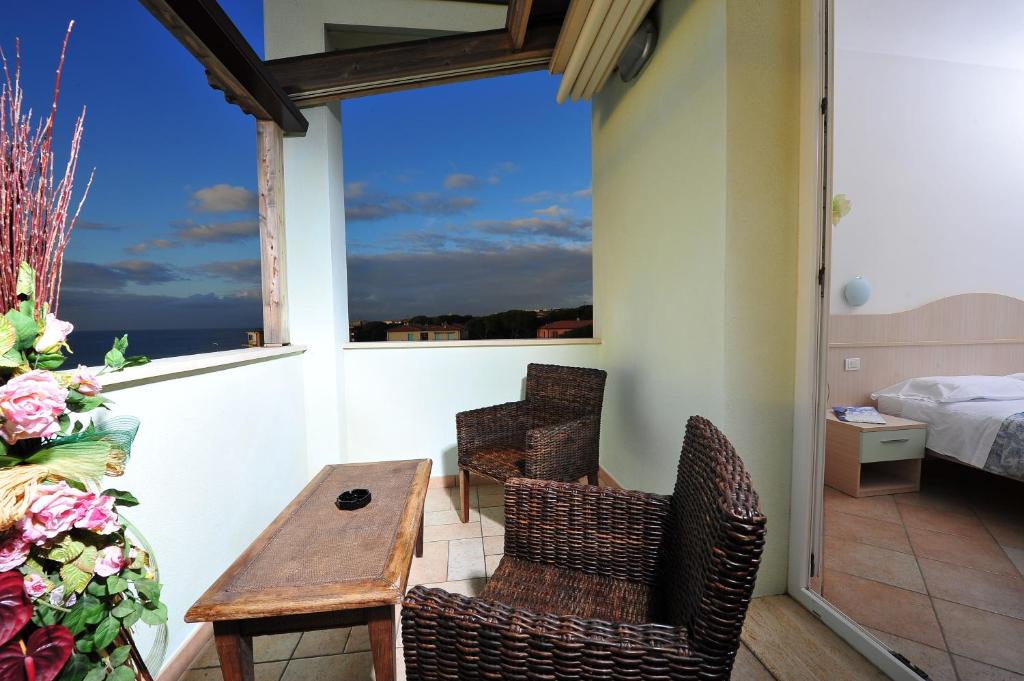 a room with a table and chairs on a balcony at Hotel Aurora in San Vincenzo